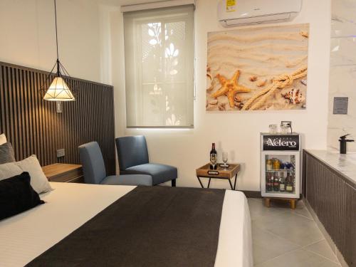 a hotel room with a bed and a table and chair at Hotel velero in Roldanillo