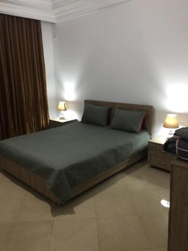 1 dormitorio con 1 cama grande con 2 lámparas y 1 cama sidx sidx sidx sidx sidx sidx en un nouveau appartement avec un parking gratuit sur place en La Marsa