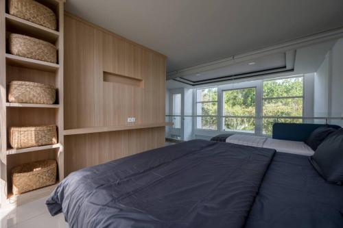 a bedroom with a large bed and a large window at The View Villa 2 - 2br Minimalist Villa in Uluwatu in Uluwatu