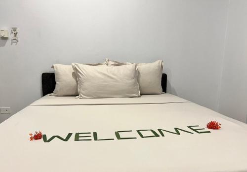 a bed with the word welcome written on it at Garden Apartments in Nadi