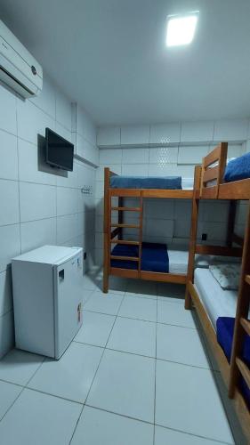 a room with two bunk beds and a television at Pousada Bomfim in Maceió