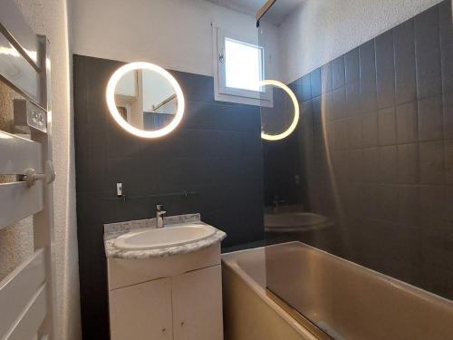 a bathroom with a sink and a tub and a mirror at Appartement Les Deux Alpes, 2 pièces, 4 personnes - FR-1-516-210 in Les Deux Alpes
