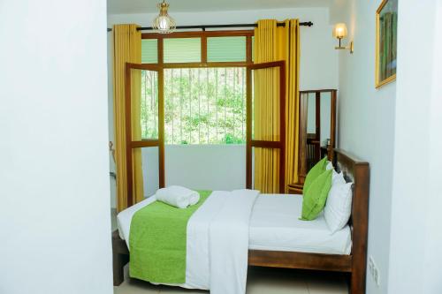 sypialnia z łóżkiem i oknem w obiekcie Maharajah Grand w mieście Hatton