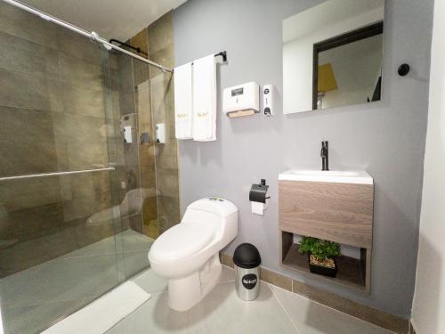 a bathroom with a toilet and a shower and a sink at Hotel velero in Roldanillo