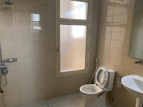 アブダビにあるYour Studio Near Airport and allのバスルーム(トイレ、洗面台付)、窓が備わります。