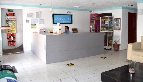 a man sitting at a counter in a store at Hotel Las Vegas by CMS hotels in Santa Marta