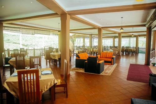 ein Speisesaal mit Tischen und Stühlen und ein Restaurant in der Unterkunft Maharajah Grand in Hatton