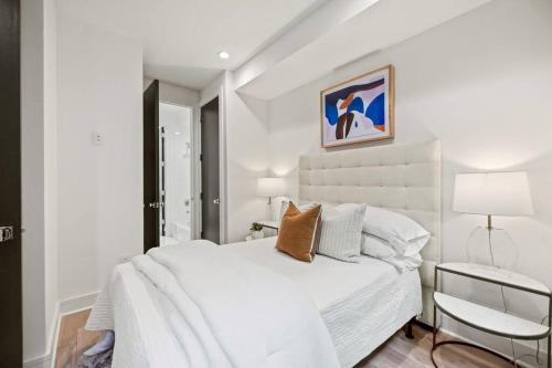 ein weißes Schlafzimmer mit einem weißen Bett und einem Stuhl in der Unterkunft Logan Circle Penthouse and Rooftop Unit A in Washington