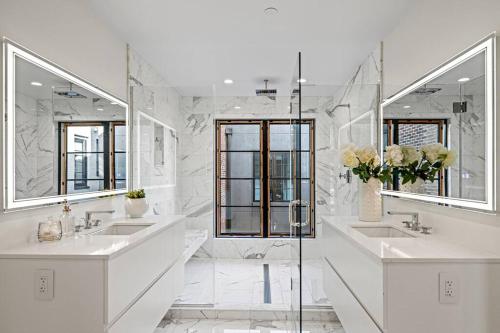 ein weißes Badezimmer mit zwei Waschbecken und zwei Spiegeln in der Unterkunft Logan Circle Penthouse and Rooftop Unit A in Washington