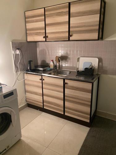a kitchen with a sink and a washing machine at Your Studio Near Airport and all in Abu Dhabi