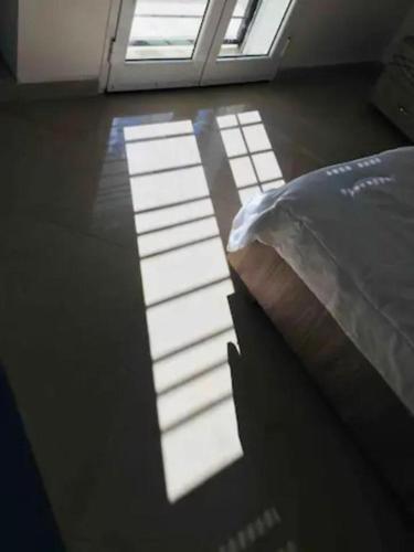 a bedroom with a bed and a window with sunlight at un nouveau appartement avec un parking sur place in La Marsa