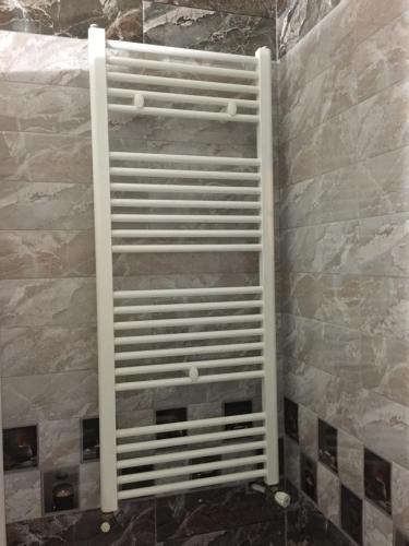 a metal shelf in a bathroom with a stone wall at un nouveau appartement avec un parking gratuit sur place in La Marsa