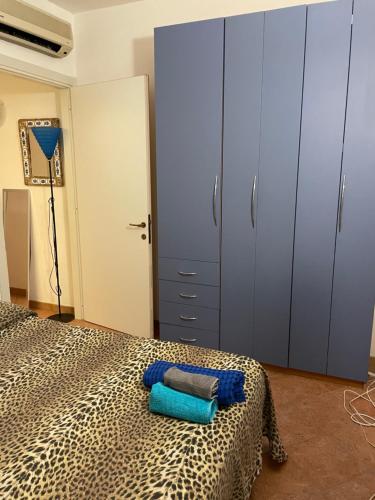 Un dormitorio con una cama con toallas azules. en Airport at 25 min by walk - 5 min by walk to commercial center 2 min by walk to touristic port for trip to islands 5 min by walk to bus for city and beaches -Balcony sunset and Sea view-wi fi-air cond-5 persons-pool from 15 june to 15 september PISCINA en Olbia
