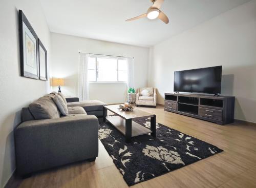 a living room with a couch and a flat screen tv at Tumon Isa 16 Condo in Tamuning
