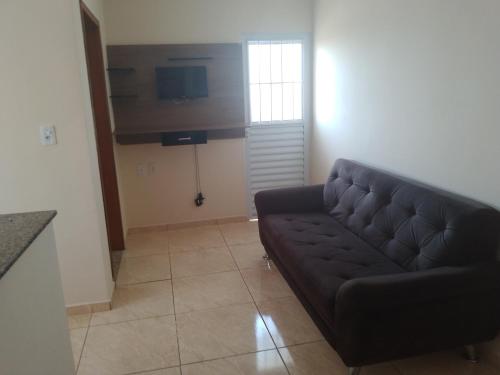 ein Wohnzimmer mit einem Sofa und einem TV in der Unterkunft Bem estar in Aparecida