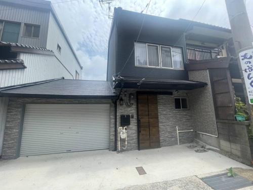 a house with a garage with a door at 壇ノ浦ハウス in Shimonoseki