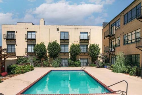 an apartment building with a swimming pool in front of a building at Serene Living Downtown STL Loft in Saint Louis