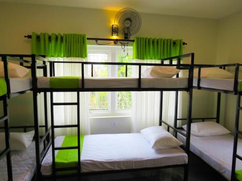 three bunk beds in a room with a window at Havelock City Hostel, Colombo in Colombo