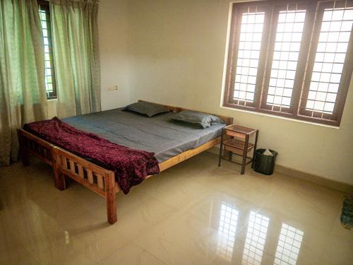 um quarto com uma cama num quarto com janelas em Body Manthra em Varkala