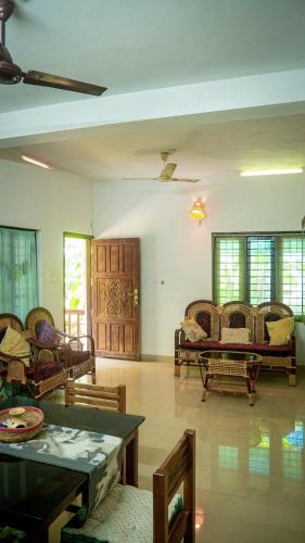 uma sala de estar com sofás e uma mesa em Body Manthra em Varkala