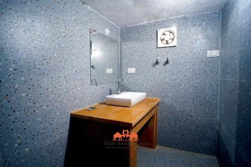 een badkamer met een wastafel en een spiegel bij Sam Sand Dunes Desert Safari Camp in Jaisalmer