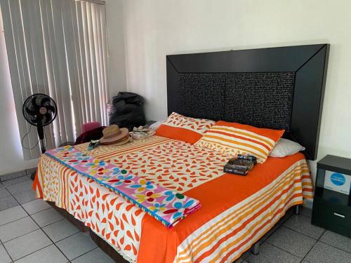 um quarto com uma cama com um edredão laranja e branco em Renta de casa de descanso / Jardín / Albercada em Tlayecac