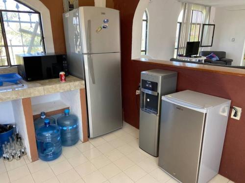 uma cozinha com 2 frigoríficos e um balcão com garrafas de água em Renta de casa de descanso / Jardín / Albercada em Tlayecac