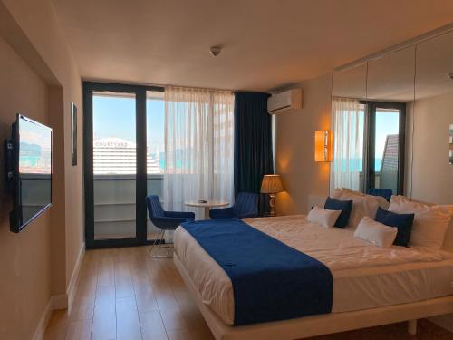 ein Hotelzimmer mit einem großen Bett und einem großen Fenster in der Unterkunft Orbi floor40 in Batumi