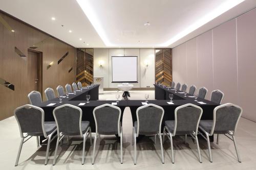 a conference room with a large black table and chairs at City Garden Suites Manila in Manila
