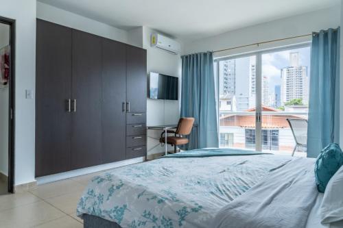 um quarto com uma cama grande e uma janela grande em Apartamento en San Francisco na Cidade do Panamá