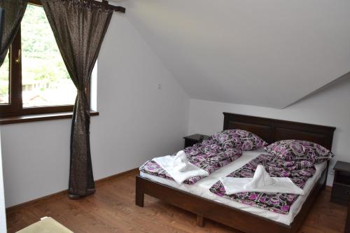 a bedroom with a bed and a window at Vila Golful Dunării in Dubova