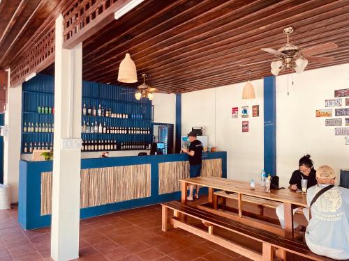 a bar with two people sitting at a table at The Jam Hostel Luang Prabang in Luang Prabang