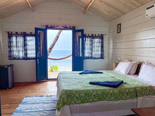 a bedroom with a bed with a view of the ocean at The Nest Palolem in Canacona