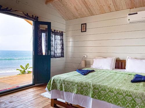 a bedroom with a bed and a view of the ocean at The Nest Palolem in Canacona