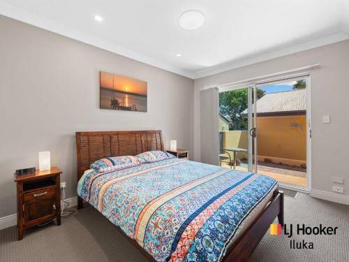 ein Schlafzimmer mit einem Bett und einem großen Fenster in der Unterkunft Riverview Apartments 1 3 Building 1 Unit 3 in Iluka