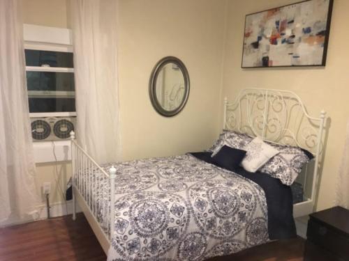 Un dormitorio con una cama blanca y un espejo. en Urban Oasis with Private Laundry: Steps from DTLA, en Los Ángeles