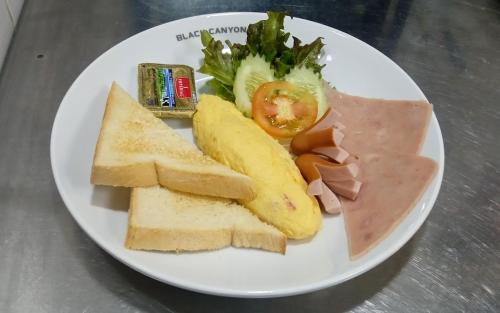 a white plate of food with bread and fruit and vegetables at Sea Star House in Ao Nang Beach