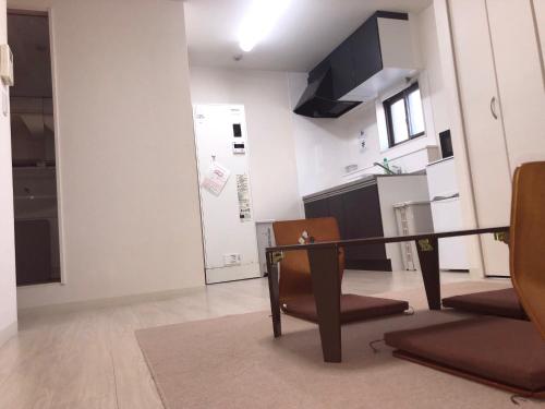 a kitchen and a living room with a table and chairs at Apartment Heights HANA in Sakai