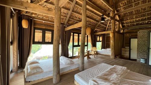 une chambre avec deux lits dans une pièce avec des plafonds en bois dans l'établissement La Montana De Luong Son, à Chân Miên