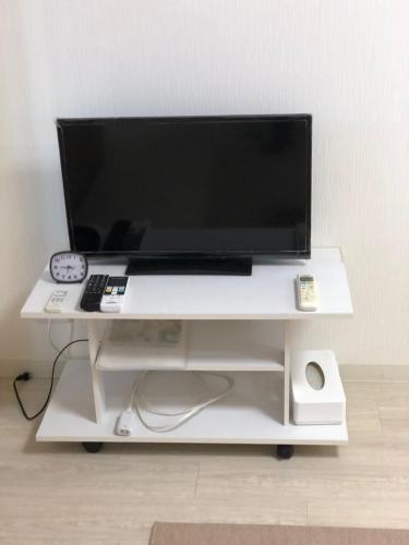 a computer monitor on a white desk with a keyboard at Apartment Heights HANA in Sakai