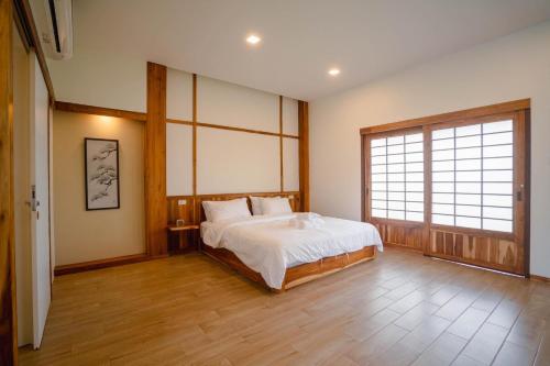 1 dormitorio con cama y ventana grande en บ้านเรียวชิน น่าน りょうしん en Nan
