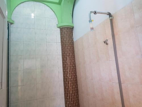 een douche in een badkamer met een bakstenen pilaar bij OYO 93237 Hotel Triarga in Takengon