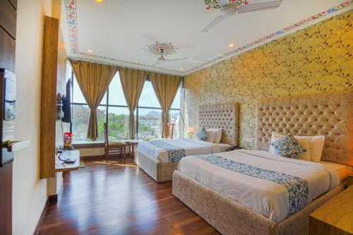 a bedroom with two beds and a large window at Pax Grand Blue in Udaipur