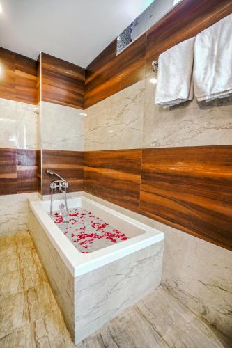 a bathroom with a bath tub with red roses on it at Pax Grand Blue - Rooftop Swimming Pool & Restaurant - 500 Mtr from Udaipur Railway station in Udaipur