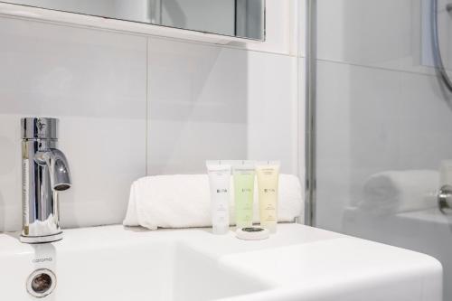 a bathroom counter with a sink and a mirror at Riverview Suites by EdgeTrip in Melbourne