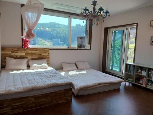 a bedroom with a large bed and a large window at Feel House in Goyang