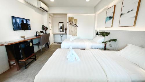 Habitación de hotel con 2 camas y escritorio en Key酒店@古城中心店 en Chiang Mai
