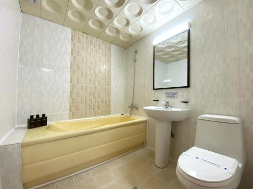 a bathroom with a tub and a toilet and a sink at Suanbo Hot Spring Healing Hotel in Chungju