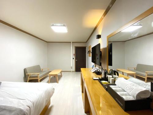 忠州市にあるSuanbo Hot Spring Healing Hotelのベッド2台とテーブルが備わるホテルルームです。