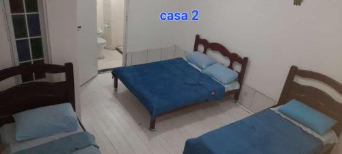 een slaapkamer met 2 bedden en blauwe kussens bij Areia Branca / Casa 1/ casa 2 in Cabo Frio